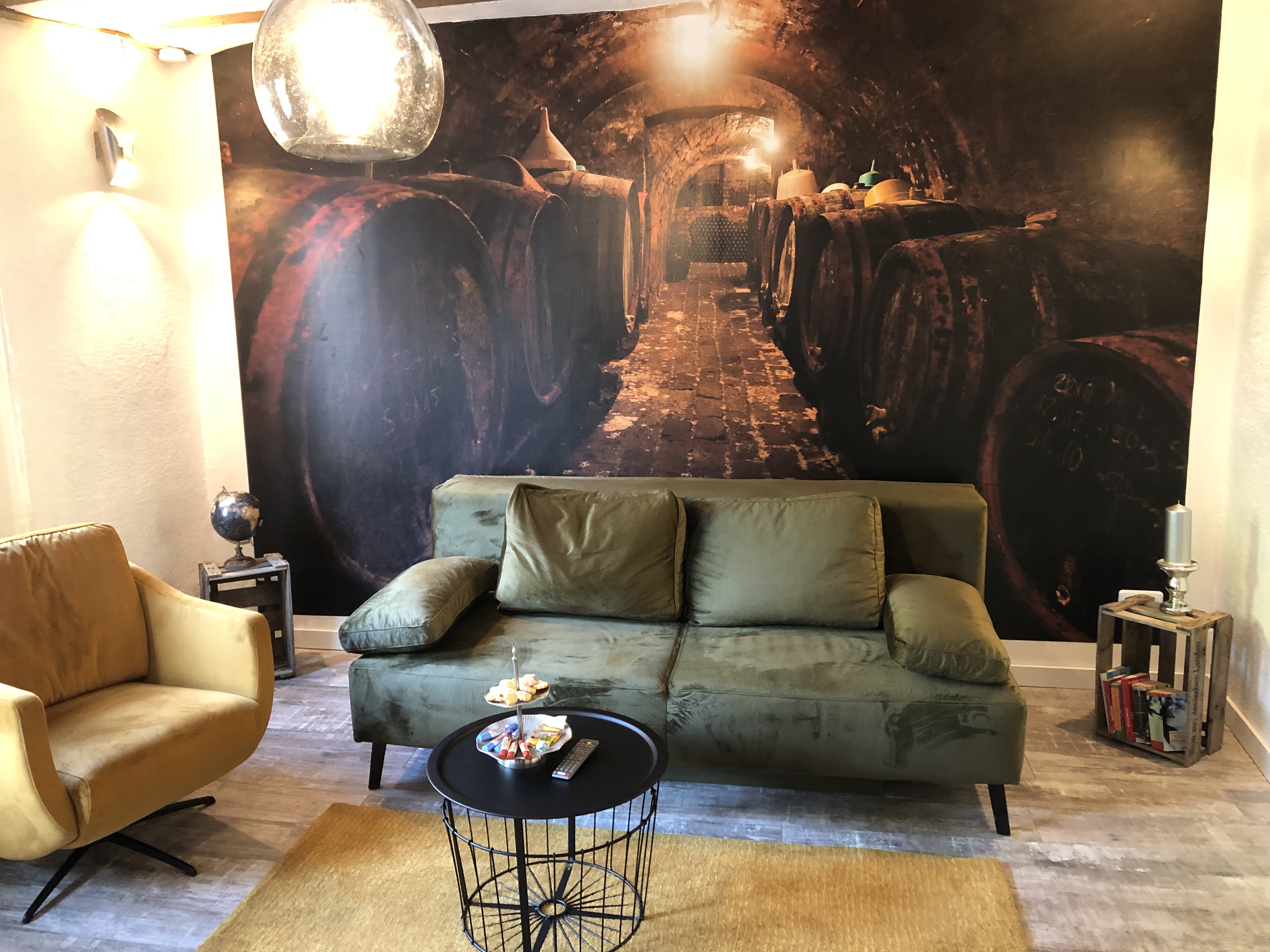 Wohnzimmer der Ferienwohnung Gewölbekeller mit historischem Wein-Wandbild