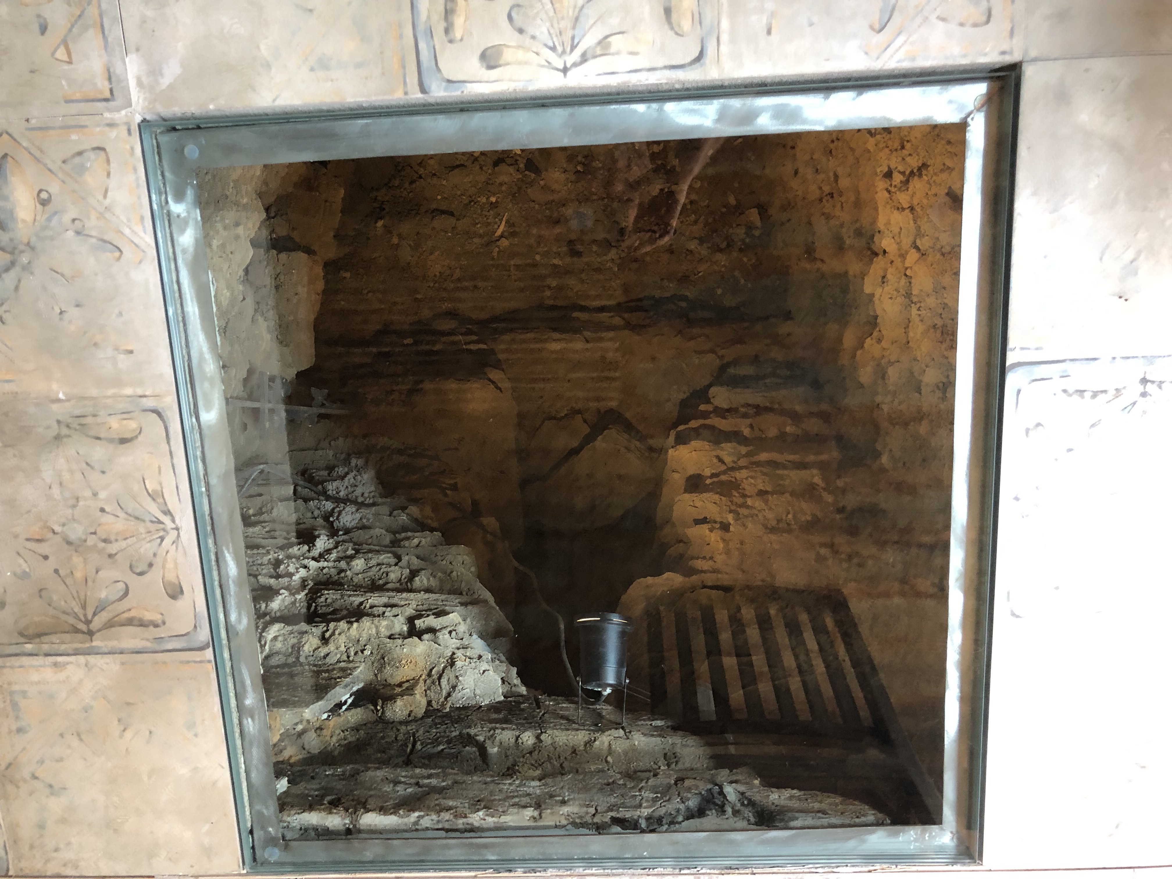 Begehbare Glasscheibe im Küchenboden mit Blick in den beleuchteten Gewölbekeller